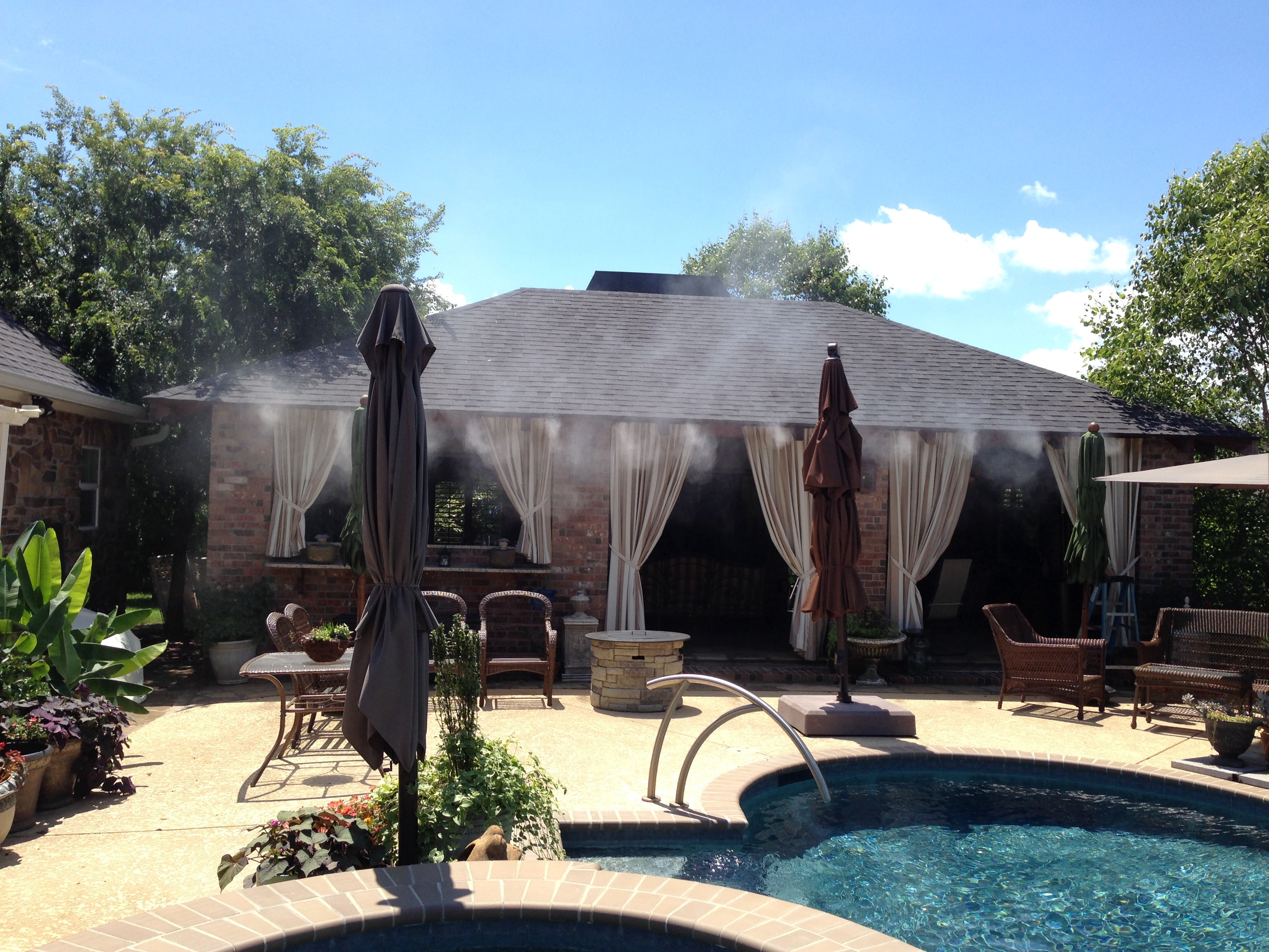 Outdoor pool patio with misting system cooling cabana